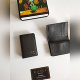 Gucci 折疊卡片夾，配以醒目的标志性雙 G 金屬配件。采用熱壓小牛皮制作，以