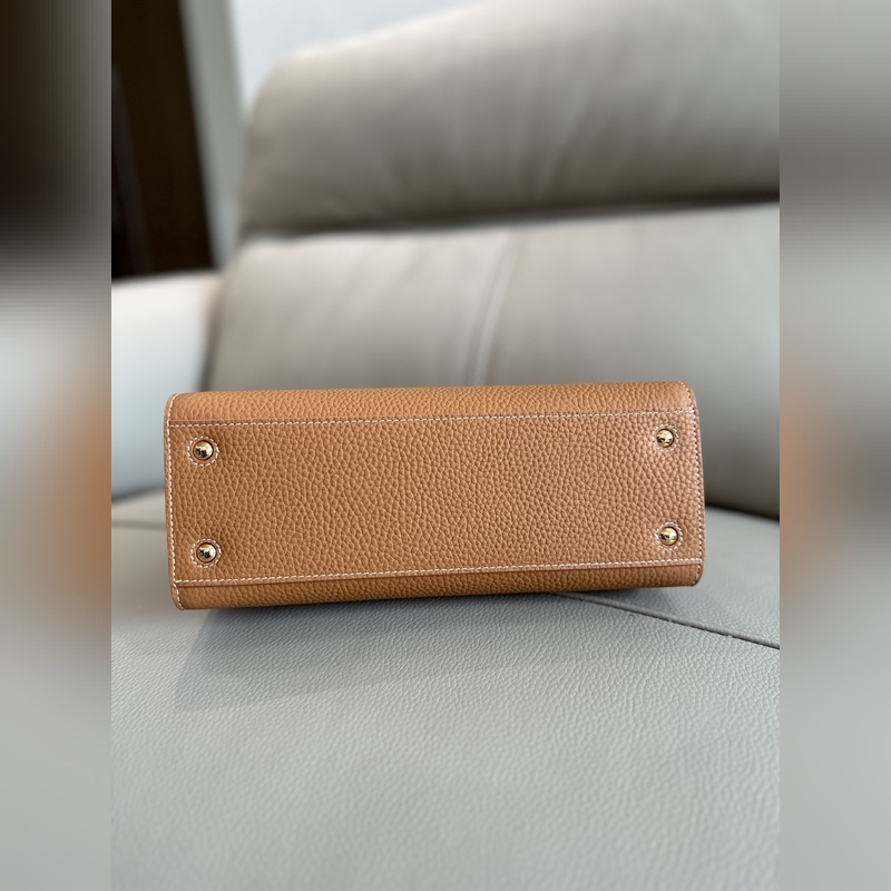 B家最新版型立挺的托特包，采用意大利鞣制粒紋皮革材質制成，搶眼裝飾光澤的 Tho