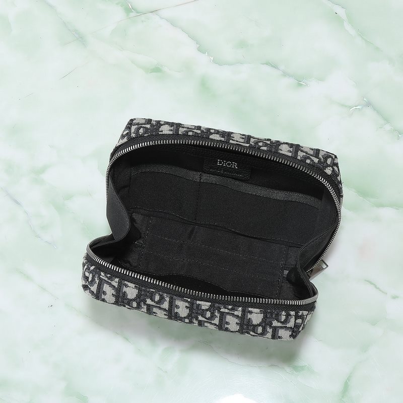 這款旅行手拿包實用又時尚。采用米色和黑色Oblique 印花面料等材質精心制作，