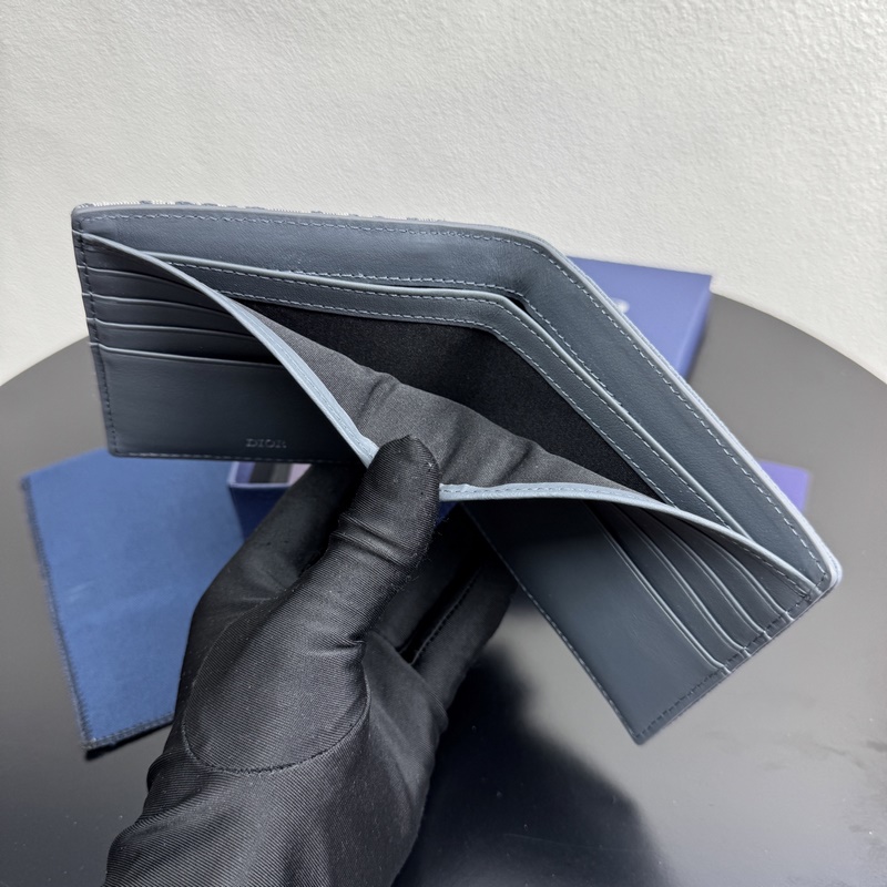 這款雙折錢包是一款小巧的配飾，精緻高雅。采用粒面牛皮革精心制作，正面飾以 CD