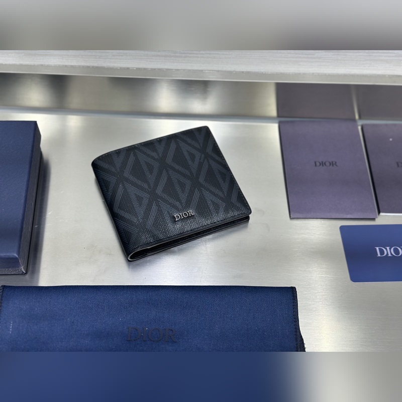 這款雙折錢包是一款小巧的配飾，精緻高雅。采用黑色粒面牛皮革精心制作，正面飾以 C