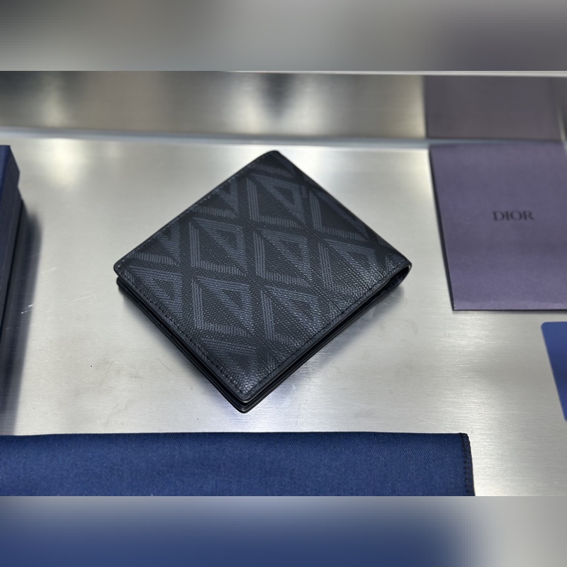 這款雙折錢包是一款小巧的配飾，精緻高雅。采用黑色粒面牛皮革精心制作，正面飾以 C