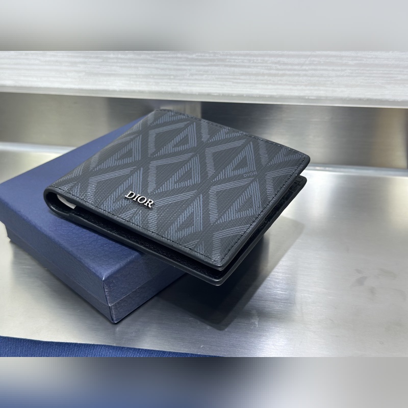 這款雙折錢包是一款小巧的配飾，精緻高雅。采用黑色粒面牛皮革精心制作，正面飾以 C