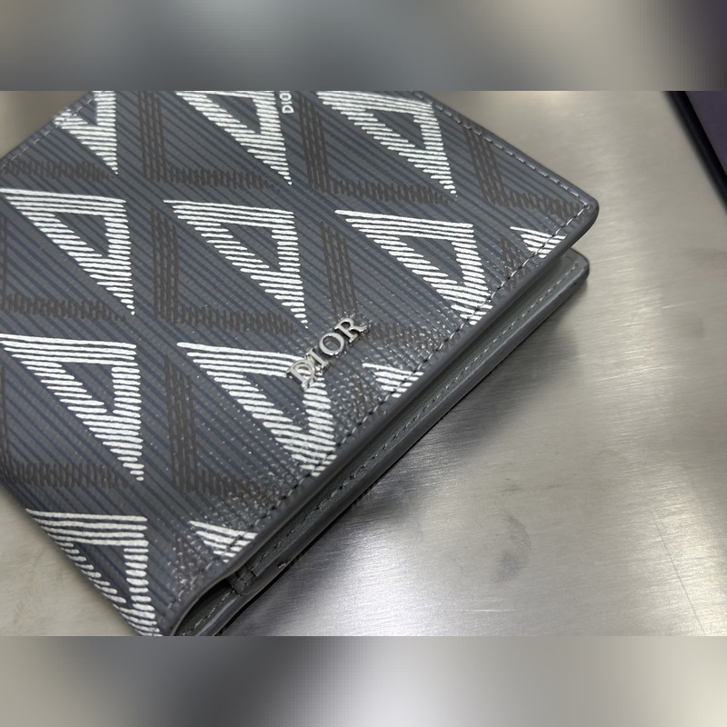 這款雙折錢包是一款小巧的配飾，精緻高雅。采用灰色粒面牛皮革精心制作，正面飾以 C