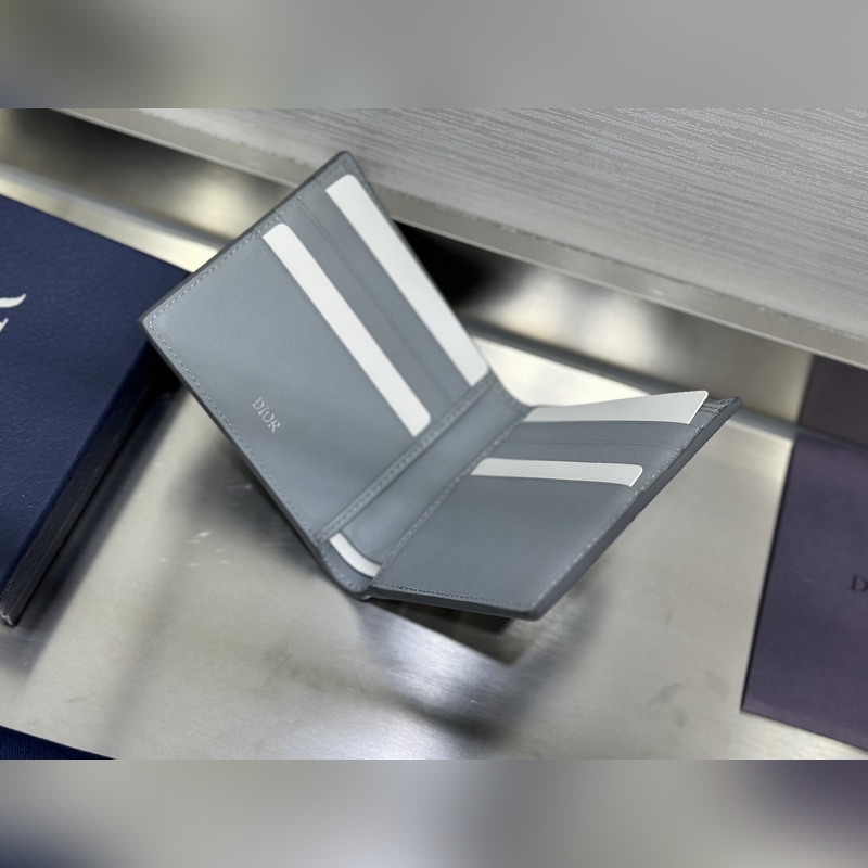 這款雙折錢包是一款小巧的配飾，精緻高雅。采用灰色粒面牛皮革精心制作，正面飾以 C