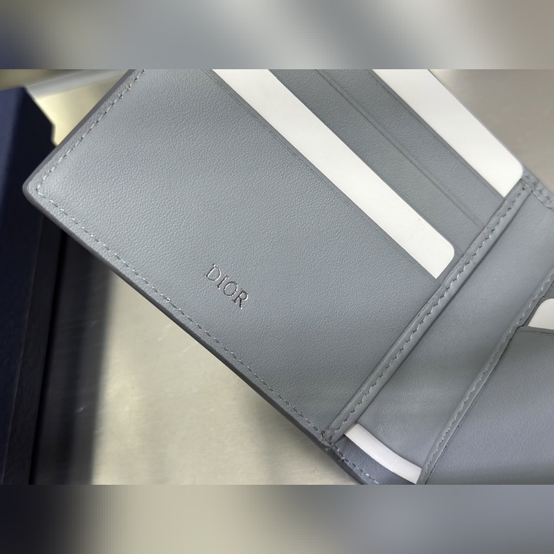 這款雙折錢包是一款小巧的配飾，精緻高雅。采用灰色粒面牛皮革精心制作，正面飾以 C