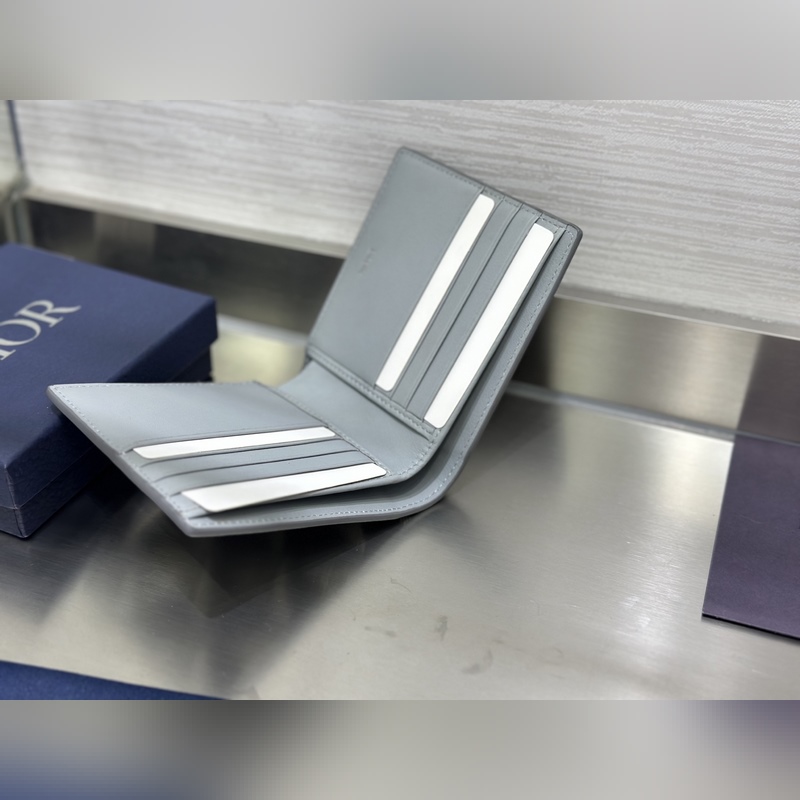 這款雙折錢包是一款小巧的配飾，精緻高雅。采用灰色粒面牛皮革精心制作，正面飾以 C