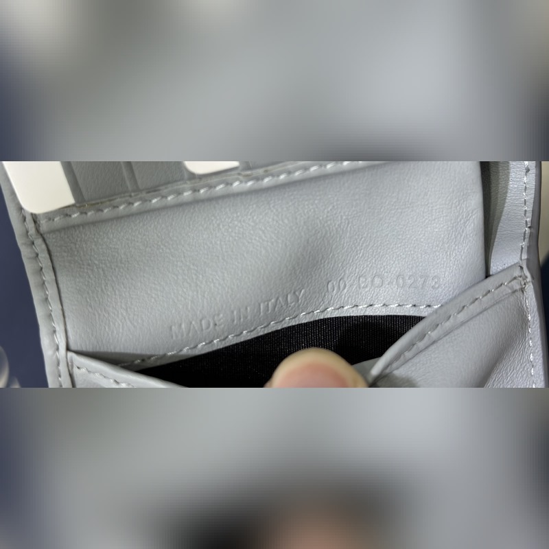 這款雙折錢包是一款小巧的配飾，精緻高雅。采用灰色粒面牛皮革精心制作，正面飾以 C