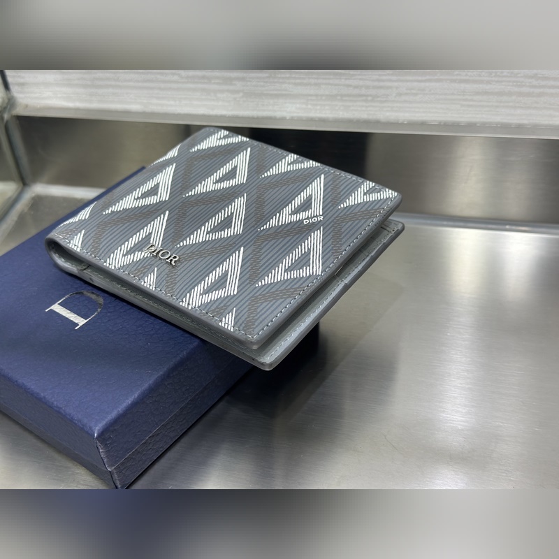 這款雙折錢包是一款小巧的配飾，精緻高雅。采用灰色粒面牛皮革精心制作，正面飾以 C