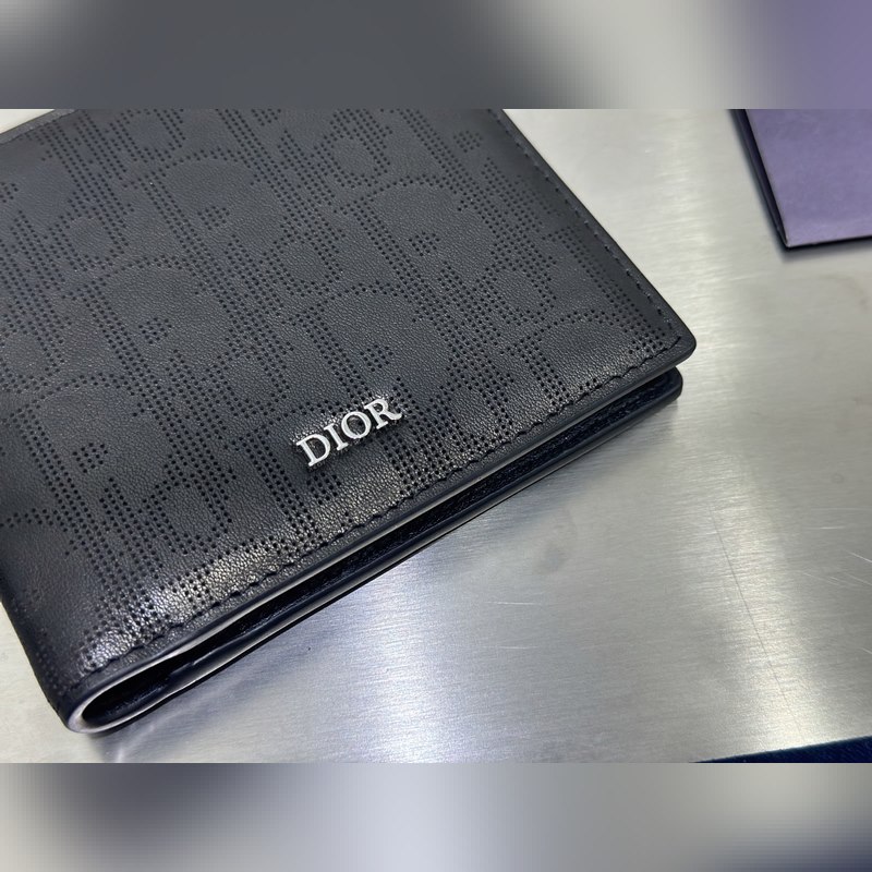 這款雙折錢包是一款小巧的配飾，精緻高雅。采用黑色粒面牛皮革精心制作，正面飾以 C