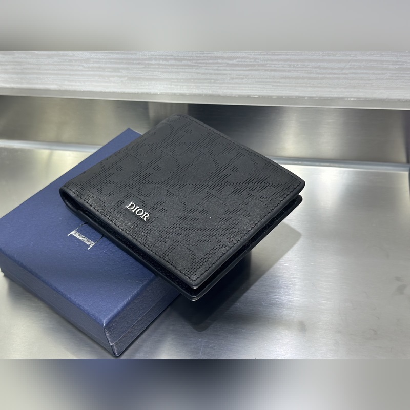 這款雙折錢包是一款小巧的配飾，精緻高雅。采用黑色粒面牛皮革精心制作，正面飾以 C