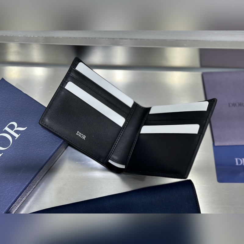 這款雙折錢包是一款小巧的配飾，精緻高雅。采用黑色粒面牛皮革精心制作，正面飾以 C