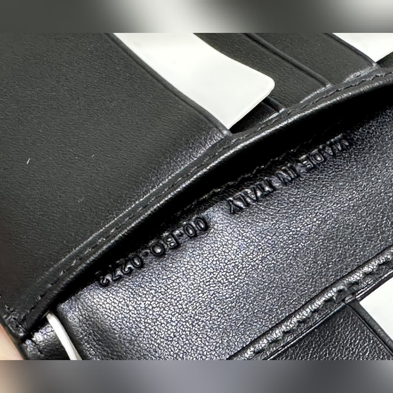 這款雙折錢包是一款小巧的配飾，精緻高雅。采用黑色粒面牛皮革精心制作，正面飾以 C