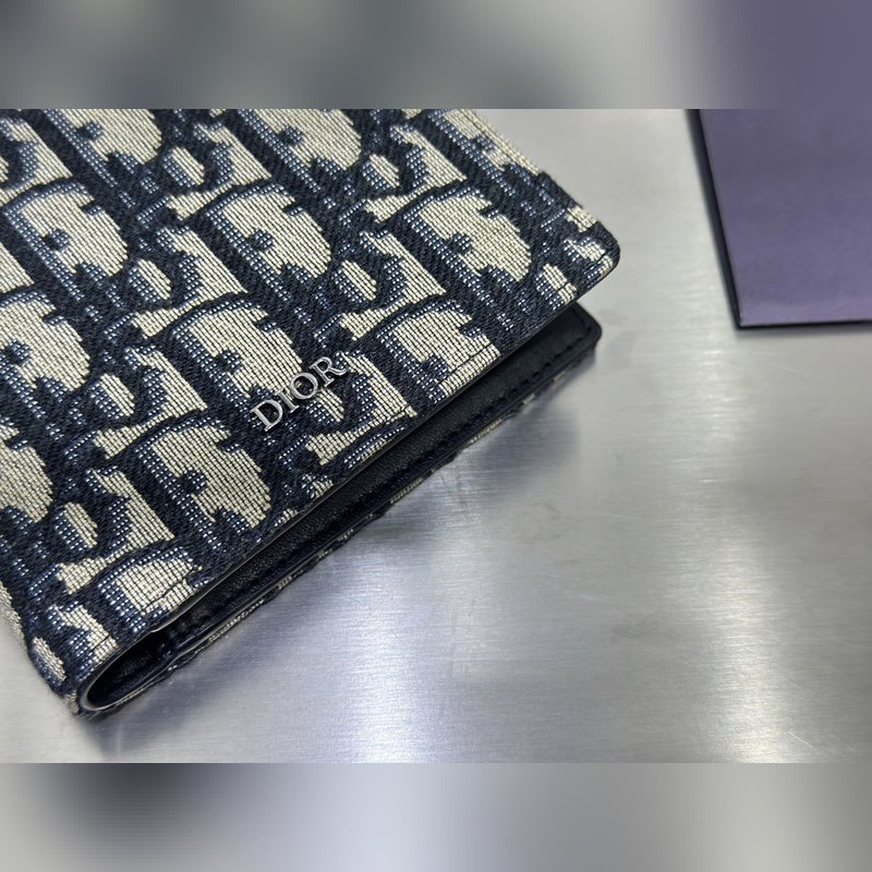 這款雙折錢包是一款小巧的配飾，精緻高雅。采用黑色粒面牛皮革精心制作，正面飾以 C