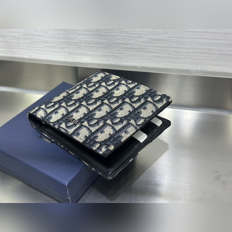 這款雙折錢包是一款小巧的配飾，精緻高雅。采用黑色粒面牛皮革精心制作，正面飾以 C