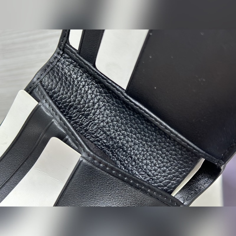 這款雙折錢包是一款小巧的配飾，精緻高雅。采用黑色粒面牛皮革精心制作，正面飾以 C