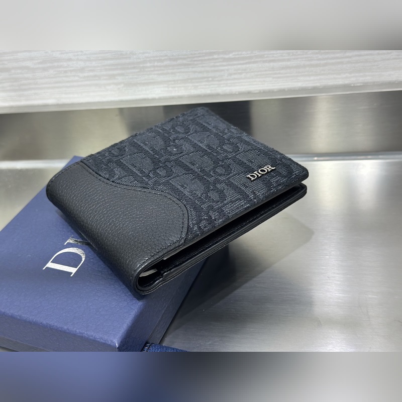 這款雙折錢包是一款小巧的配飾，精緻高雅。采用黑色粒面牛皮革精心制作，正面飾以 C