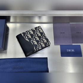 這款雙折錢包是一款小巧的配飾，精緻高雅。采用黑色粒面牛皮革精心制作，正面飾以 C