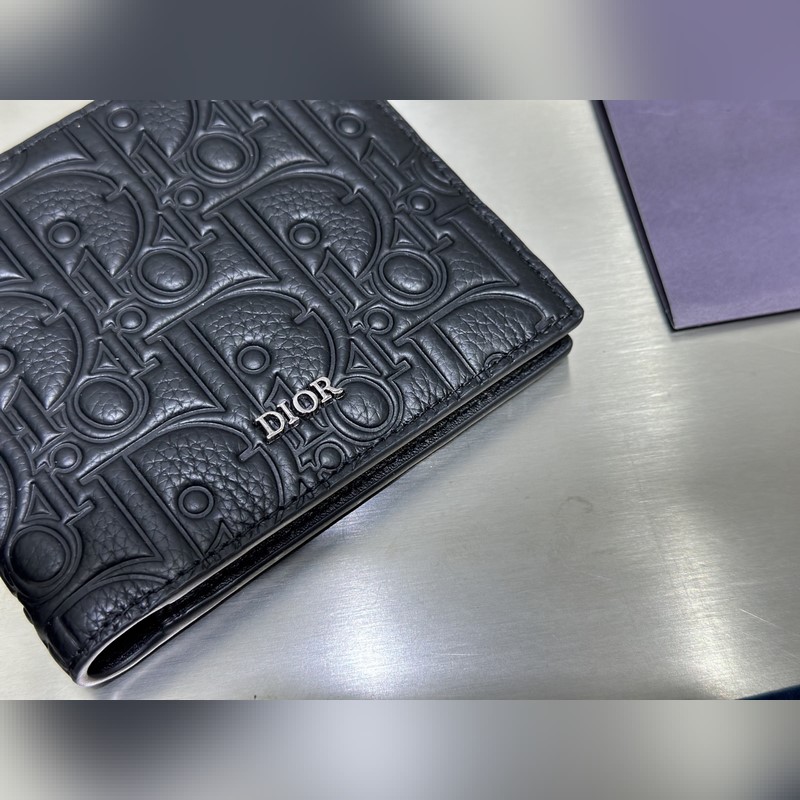 這款雙折錢包是一款小巧的配飾，精緻高雅。采用黑色粒面牛皮革精心制作，正面飾以 C