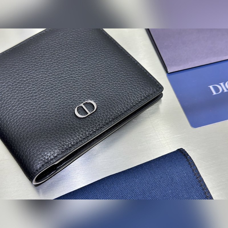 這款雙折錢包是一款小巧的配飾，精緻高雅。采用黑色粒面牛皮革精心制作，正面飾以 C