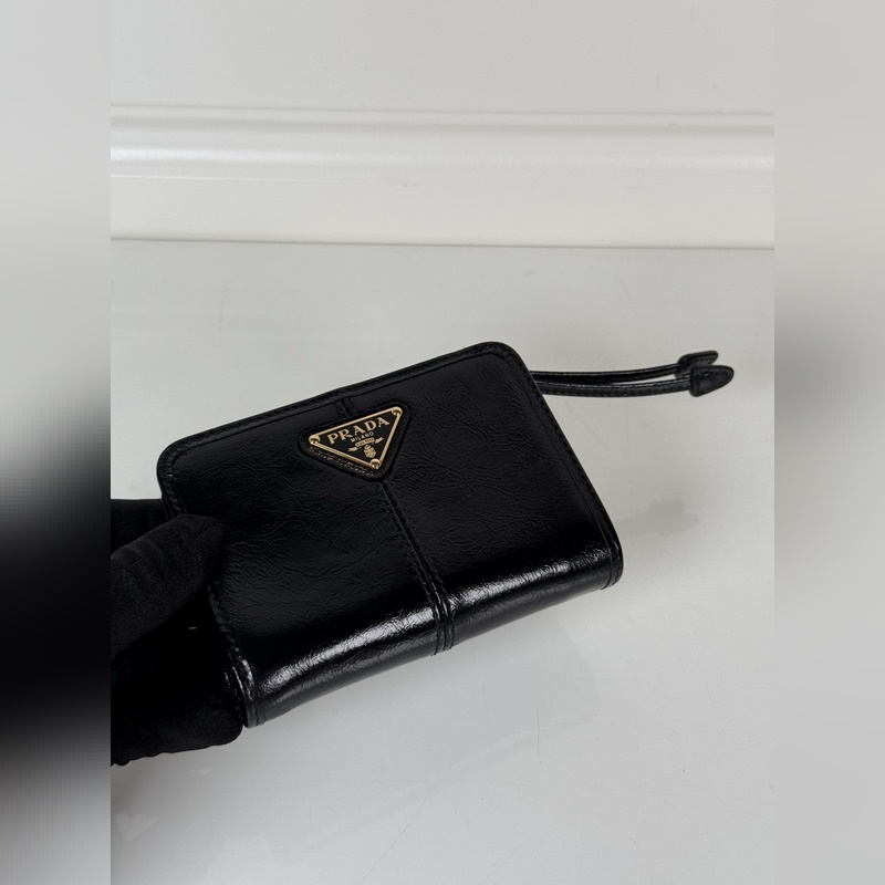 PRADA 普拉達 黑色油臘牛皮制作短夾，型號1ML018，按扣開合設(shè)計，內(nèi)設(shè)9